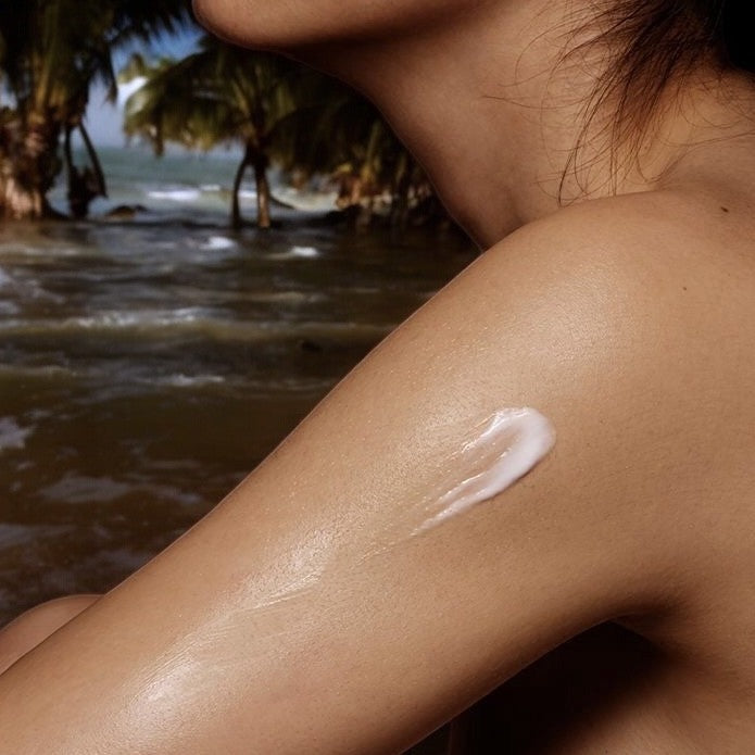 A woman wearing Ludo body lotion on the beach