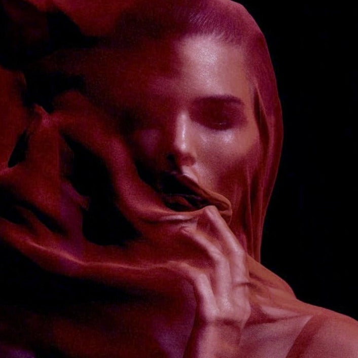 A photo of a woman's face covered with a red silk with a black background